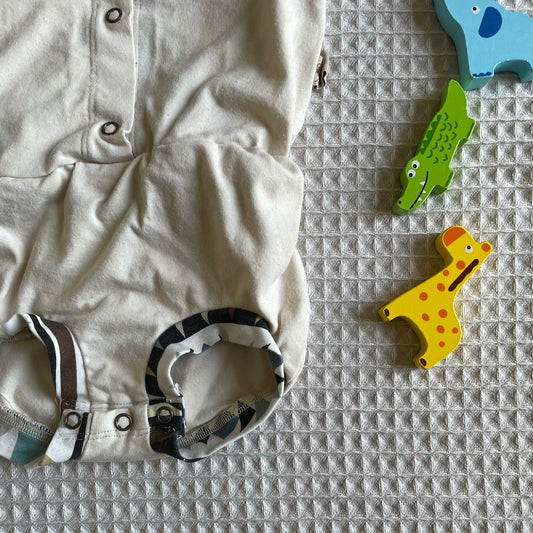 detailshot of retro model romper, designed for use with cloth diapers. Buttons