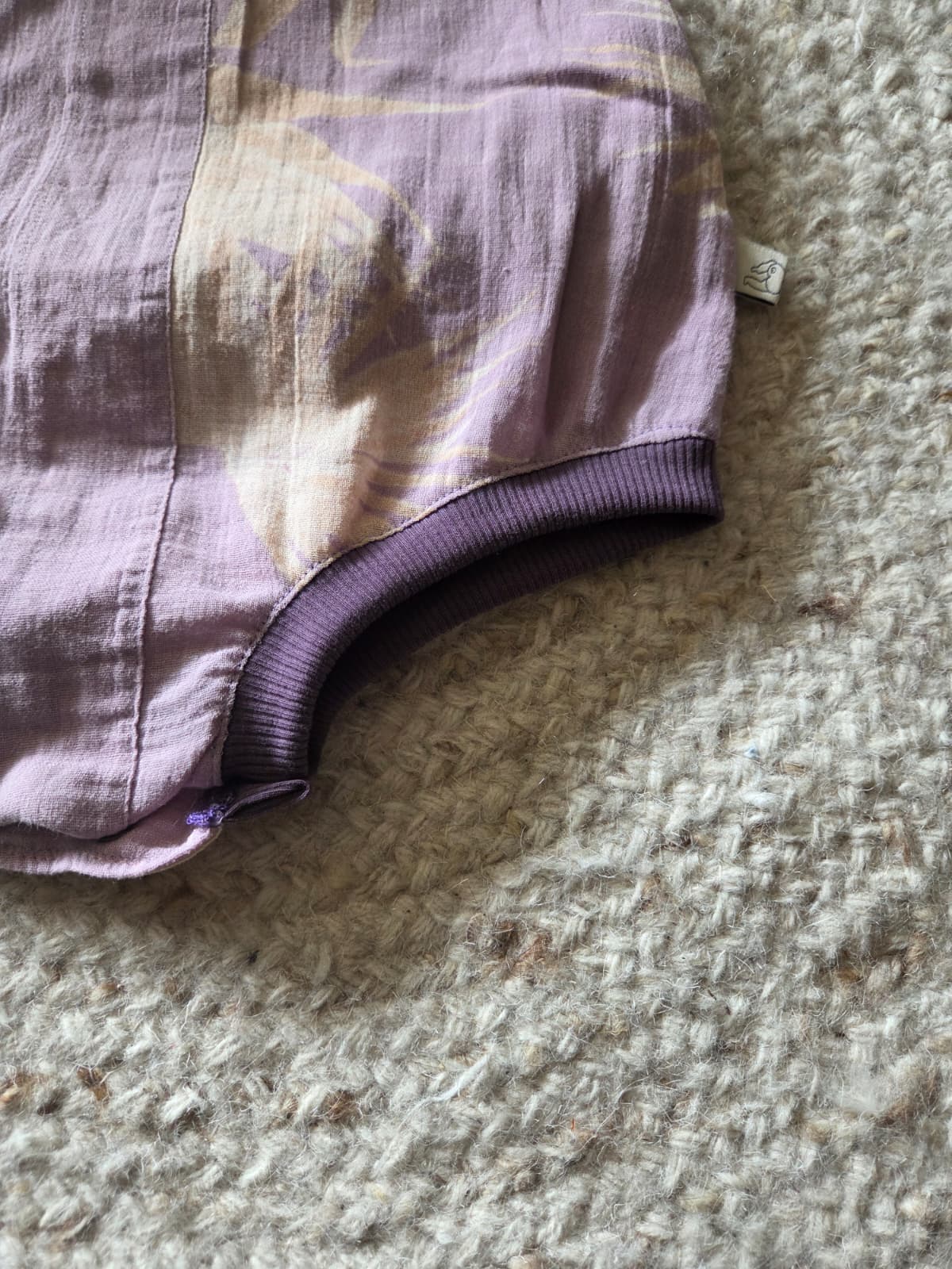 detail van zacht beenboord aan baggy romper voor wasbare luiers. Lila linnenmix