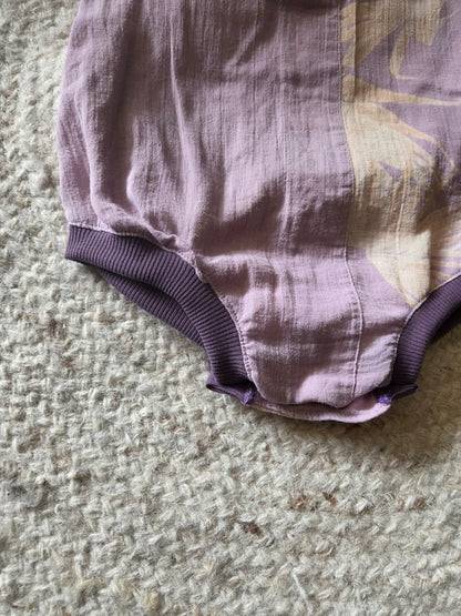 detail van kruis en knoopjes bij handgemaakte romper in linnen
