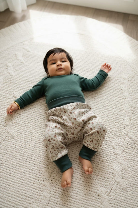 baby draagt harembroekje voor wasbare luiers, met bloemetjes